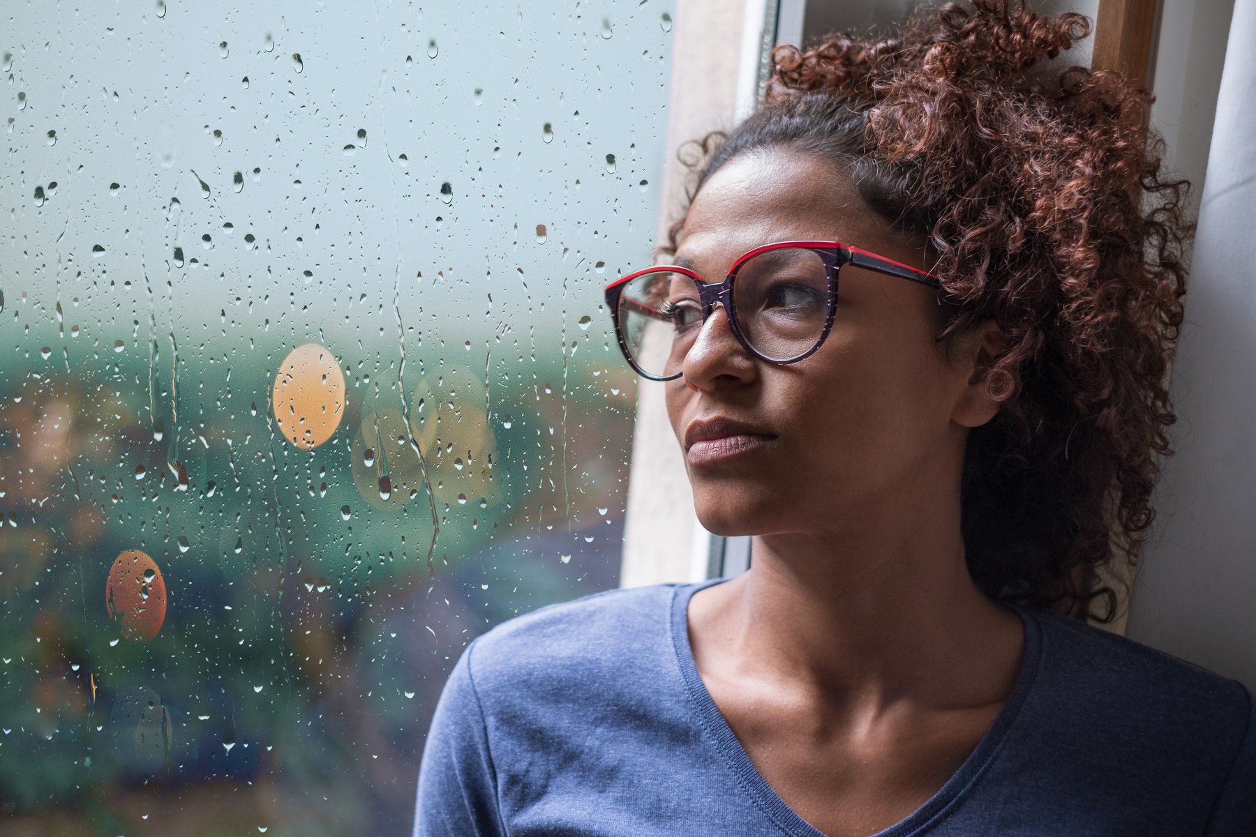 Lonely black woman near window thinking about something